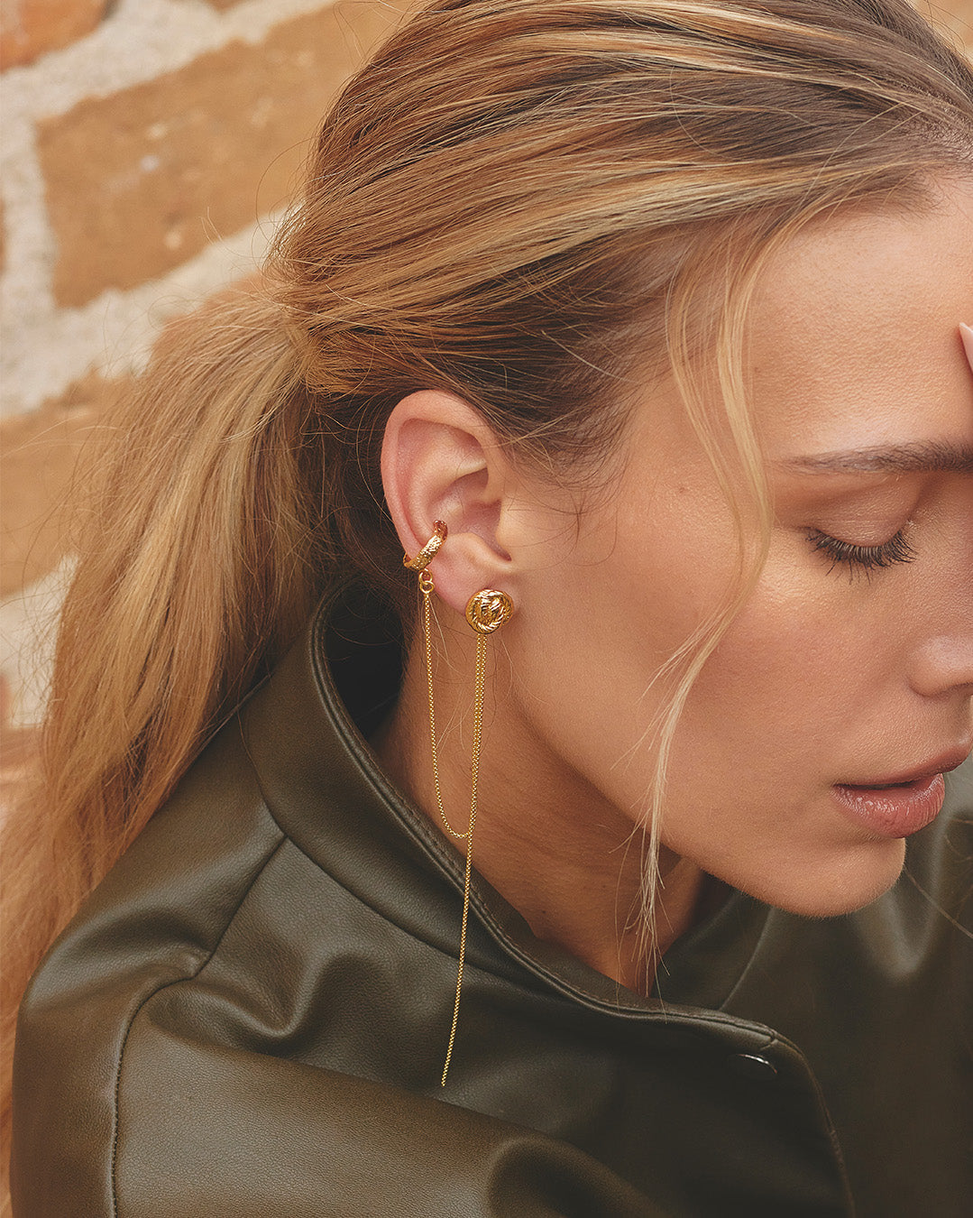 Mujer luciendo el set de Aretes Zafira que incluye  aretes nudos redondos y earcuff