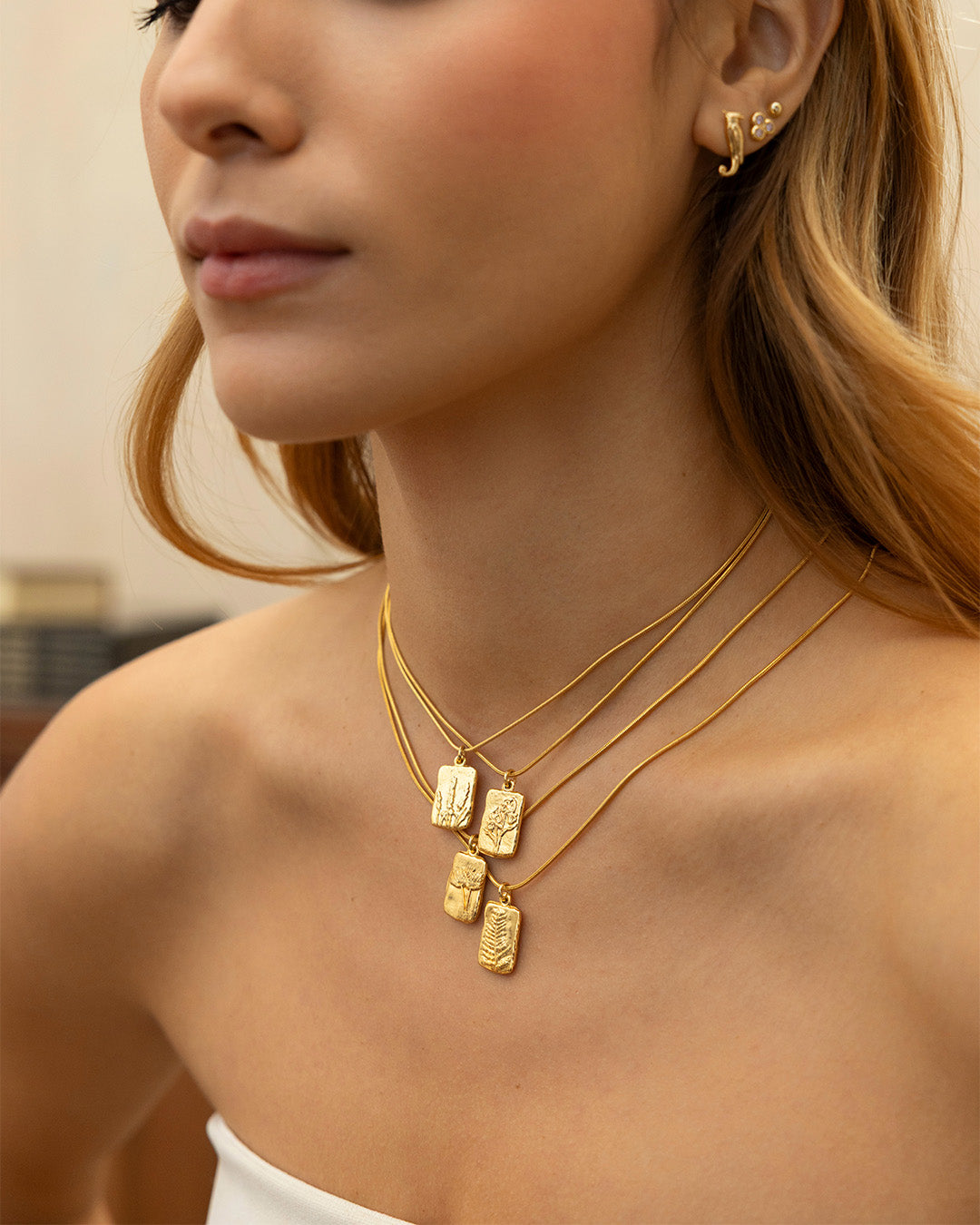 Mujer luciendo los collares Amuletos diente de león, helecho, lavanda y magnolia