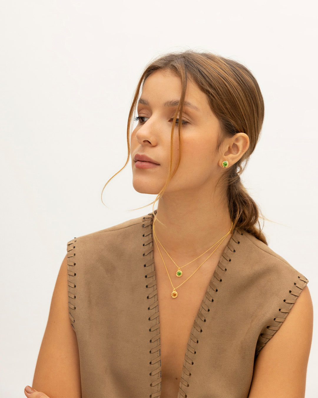 Mujer de perfil luciendo el set de Collar Cristales con dije cristal y par de topos